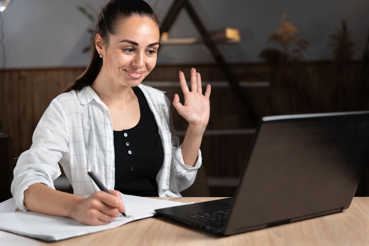 Distance learning teacher with laptop sitting in home office